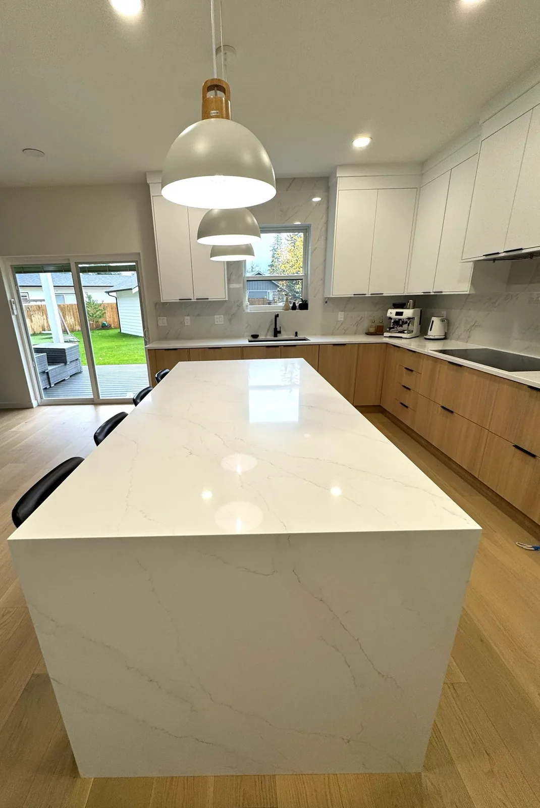 Long white waterfall island with pendant lights