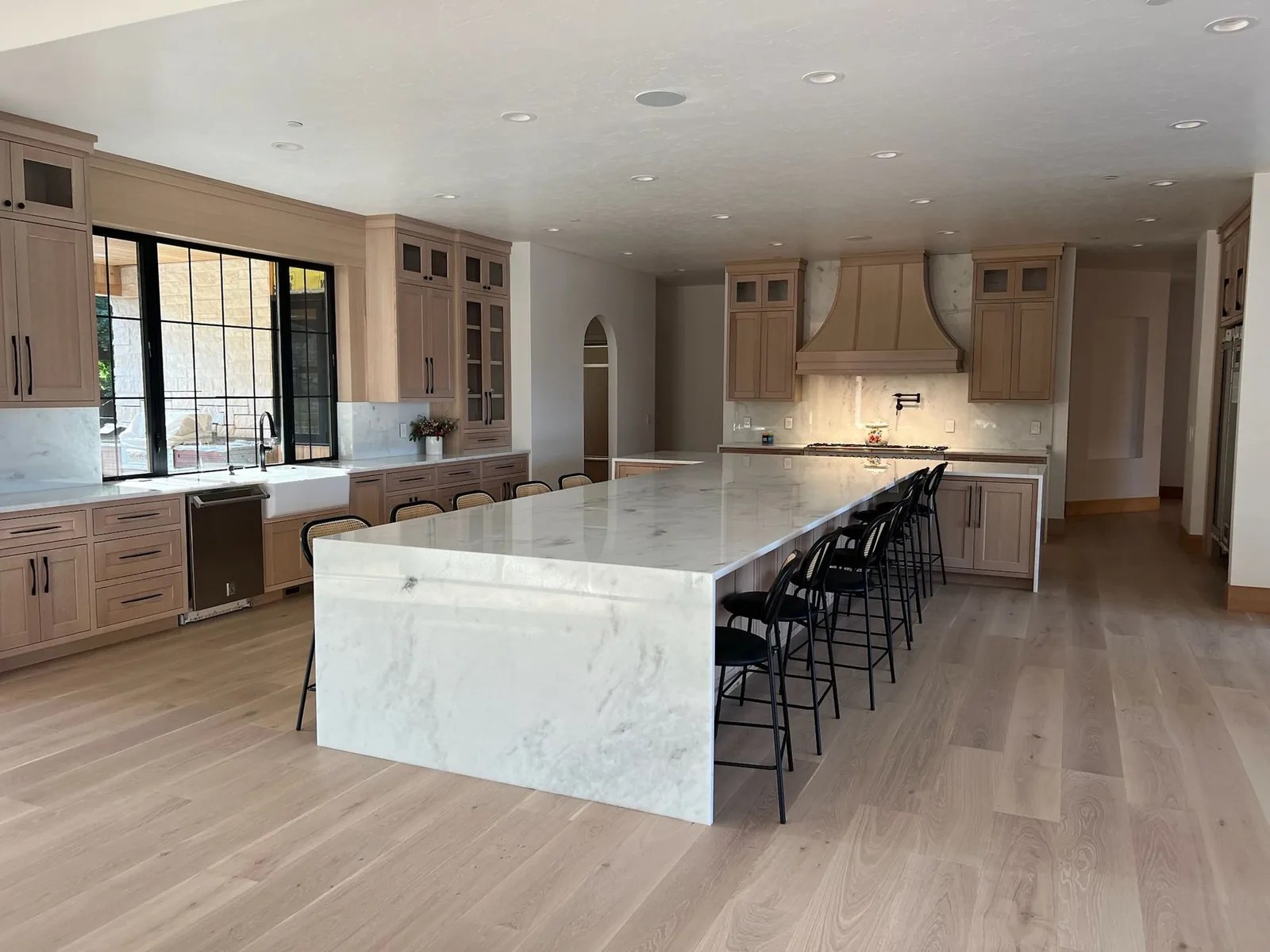 Open kitchen with a large white veined waterfall island