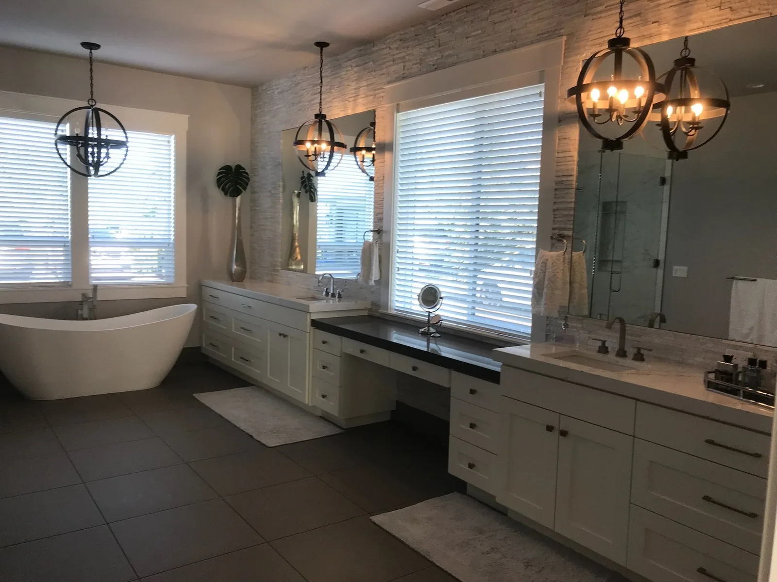 Primary bathroom with a long white vanity and makeup desk
