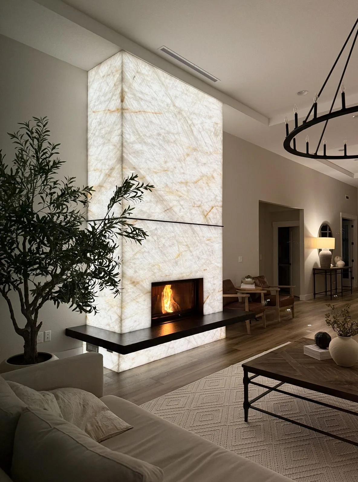 Backlit floor-to-ceiling stone fireplace wall