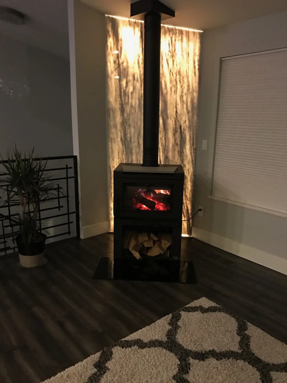 Backlit stone panel behind a wood stove