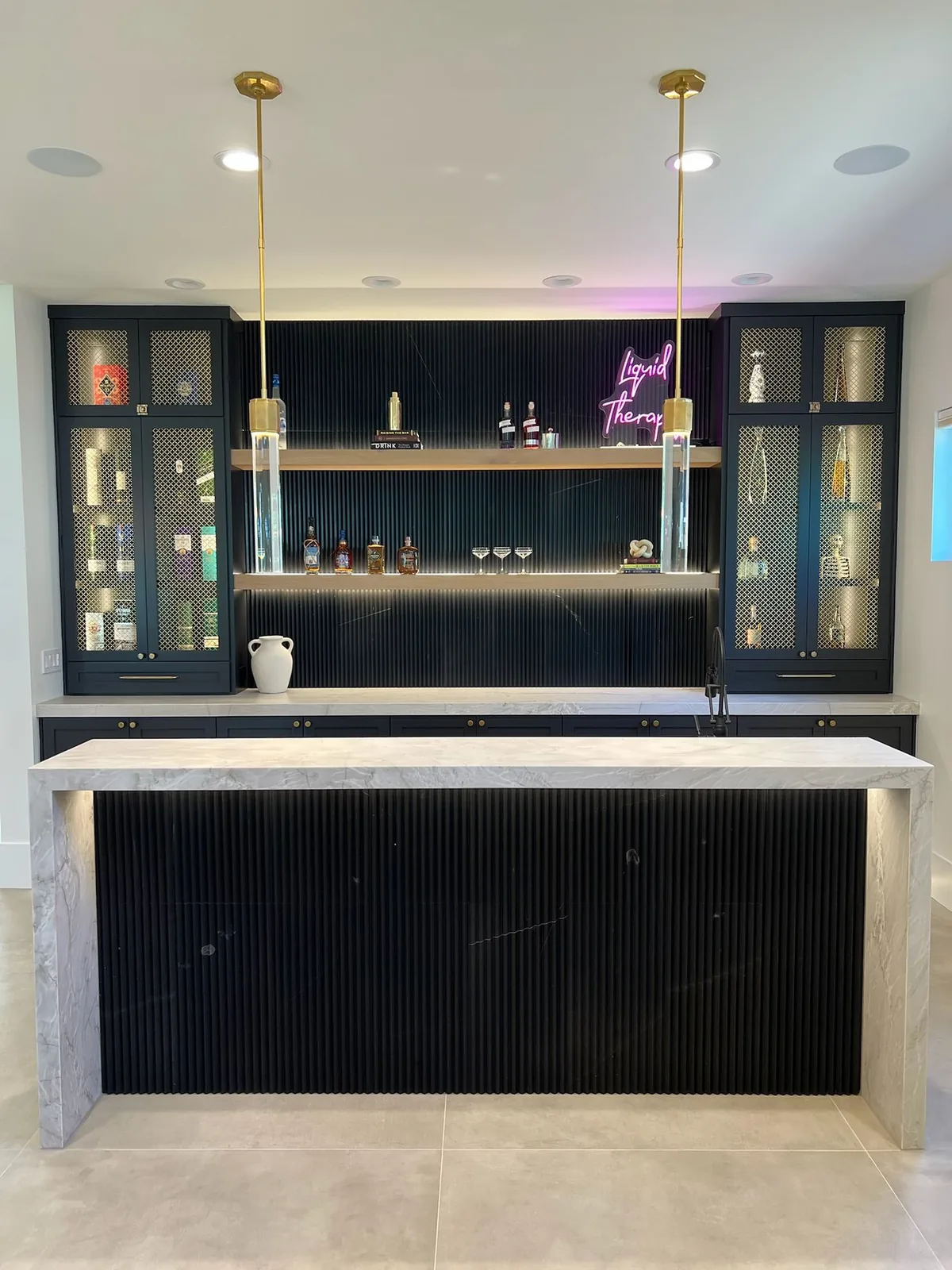 Home bar with a light waterfall countertop